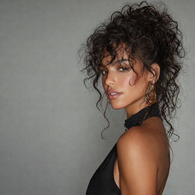 Woman with defined curls in an updo